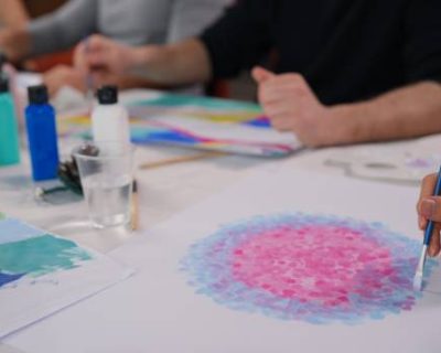 A group of multi-racial people with different ages are joining an art painting therapy session class.